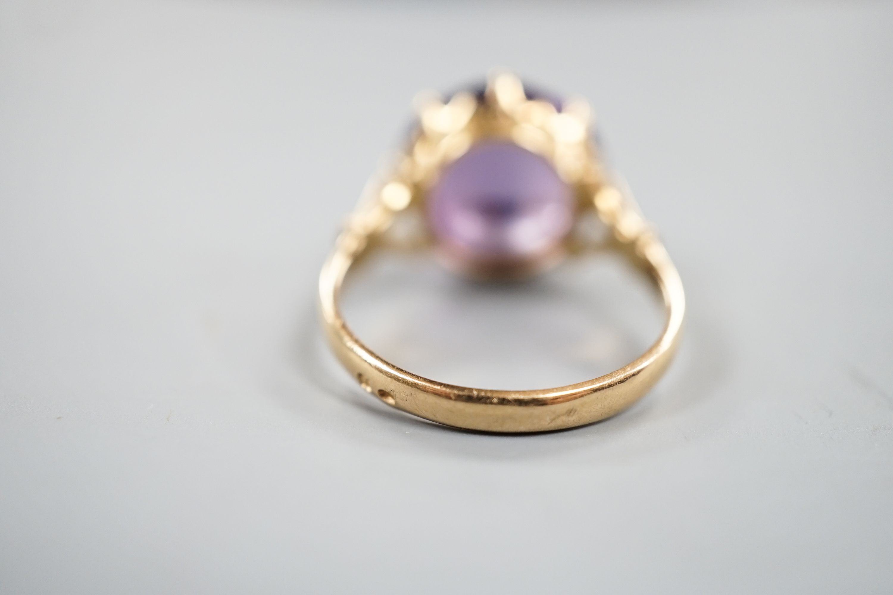 An early 20th century yellow metal and button shaped cabochon amethyst set ring, size R/S, gross weight 5.5 grams.
